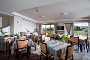 una sala da pranzo con tavoli e sedie e una cucina di Mary Hotel & Mary Royal Suites a Platanes