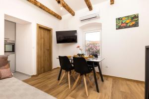 a kitchen and dining room with a table and chairs at Casa Maginja - Mediterranean Old Town Apartments in Veli Lošinj