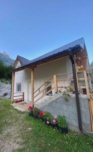 a house with a solar roof and some flowers at Guesthouse Gezim Selimaj in Valbonë +12 photos
