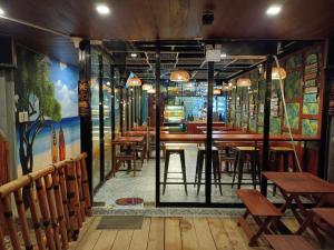 a restaurant with wooden tables and chairs in a room at Happy Daze Resort Hotel in Mabini