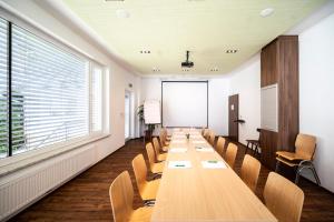 ein langer Konferenzraum mit einem langen Tisch und Stühlen in der Unterkunft Gastwirtschaft Hold in Mönichwald