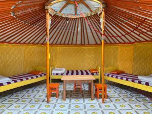 una habitación con 2 camas y una mesa en una yurta en Gaya's Guest House en Harhorin