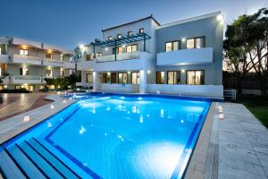 a large swimming pool in front of a house at Mary Hotel & Mary Royal Suites in Platanes