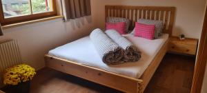 a bedroom with a wooden bed with pillows on it at Casa Gomes in Gaschurn