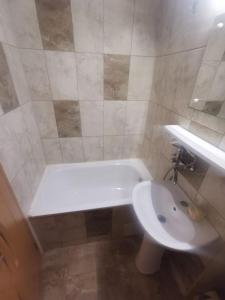 y baño con bañera blanca y lavamanos. en Apartament Ciresica, en Constanţa