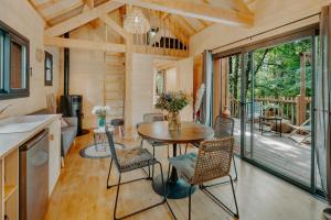 eine Küche und ein Esszimmer mit einem Tisch und Stühlen in der Unterkunft Les Cabanes Girondines-Lodges & Spa in Martillac