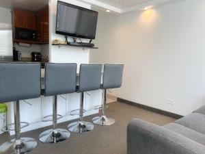 d'un salon avec quatre chaises et une télévision à écran plat. dans l'établissement Picturesque Pacific Monarch condo, à Honolulu