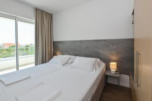 a bedroom with a white bed and a large window at VILLA CALA, Hotel Rooms&Apartments in Novalja +62 photos