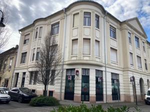 un gran edificio blanco con coches estacionados frente a él en Volenter Lux Apartment Uno en Baja