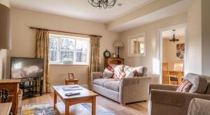 a living room with a couch and a tv at Jubilee Cottage in Rusland