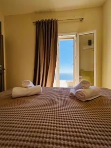 een slaapkamer met een bed met twee handdoeken erop bij Thermyes Villas 3 in Kithnos