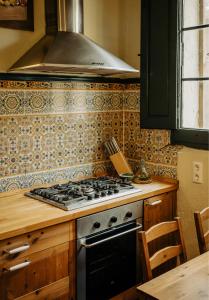a kitchen with a stove top oven in a kitchen at Casa Rural Cal Gotlla in Vilobi Del Penedes