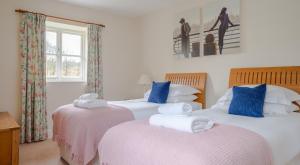 a bedroom with two beds with towels on them at Jubilee Cottage in Rusland +14 photos