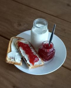 een wit bord met een broodje en een pot jam bij Lemon Tree Manor - Urban Studio in Groblersdal