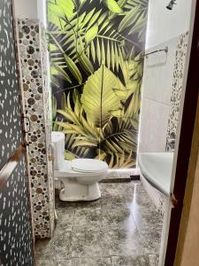 a bathroom with a toilet and a plant wall at Airport City Hotel in Katunayake
