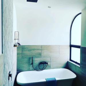 uma banheira branca na casa de banho com uma janela em Kingsbrook Pods em Clarens