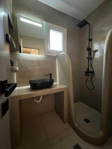 uma casa de banho com um lavatório e um chuveiro em Thermyes Villas 3 em Kythnos