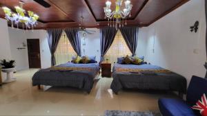 a bedroom with two beds and a chandelier at CL Homestay in Sen Monorom