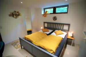 a bedroom with a bed with a yellow blanket on it at Mill Valley Villa in Koblenz