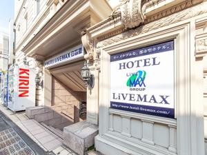 a building with a sign for a hotel luxury store at HOTEL LiVEMAX BUDGET Nippori in Tokyo