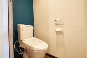 a bathroom with a white toilet in a room at New Normal Hotel in NAMINOUE ニューノーマルホテルイン波の上 in Naha