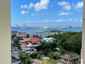 a view of a city with houses and the water at New Normal Hotel in NAMINOUE ニューノーマルホテルイン波の上 in Naha