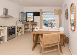 a kitchen and dining room with a table and a view of the ocean at Kanelis Milos Sea Suite in Agia Irini Milos +52 photos