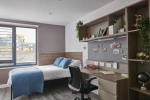 1 dormitorio con cama, escritorio y ventana en Modern Ensuites with Shared Kitchen at Howard Gardens in Cardiff, en Cardiff