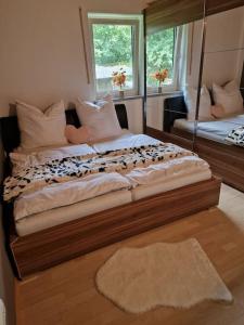 1 dormitorio con 2 camas y espejo en Ferienwohnung Bayernbrise, en Rohrdorf