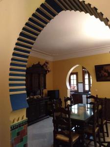 a dining room with a table and an archway at Casa Villa Las Palmeras in Arriate