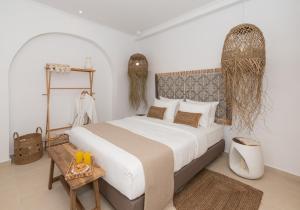 a bedroom with a large bed and a table at Kanelis Milos Sea Suite in Agia Irini Milos