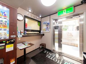 ein Restaurant Krispy Kreme mit einer Theke und einem Fenster in der Unterkunft HOTEL LiVEMAX BUDGET Nippori in Tokio
