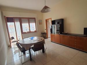 a living room with a table and a tv and a kitchen at POLA 4 in Ginosa Marina