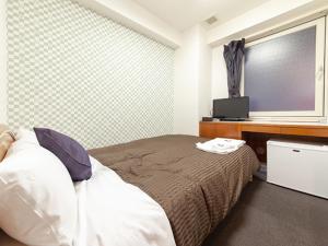Postel nebo postele na pokoji v ubytování HOTEL LiVEMAX BUDGET Nippori