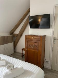a bedroom with a bed and a flat screen tv at La Maison des anges avec jardin : proche beauval in Billy