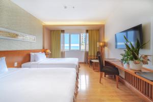 a hotel room with two beds and a desk at Saigon Hotel in Ho Chi Minh City