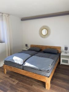 a bedroom with a wooden bed with a mirror on the wall at Haus in Esch in Esch