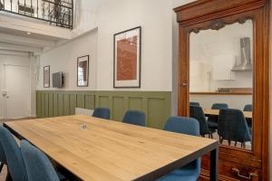 une salle de conférence avec une table en bois et des chaises bleues dans l'établissement Refuge familial urbain en plein coeur de ville, à Toulon