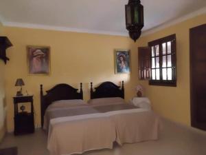 1 dormitorio con 2 camas grandes en una habitación en Casa Villa Las Palmeras, en Arriate