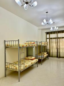 three bunk beds in a room with a ceiling at Robin Hostel Dubai in Dubai