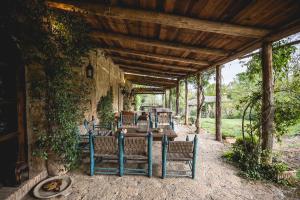 patio con tavolo e sedie sotto un soffitto in legno di Agriturismo locanda settimo cielo a Lubriano