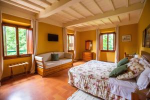 um quarto com uma cama, um sofá e janelas em Albergo Villa San Michele em Greve in Chianti