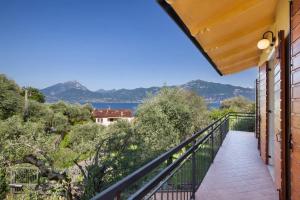 einen Balkon mit Blick auf das Wasser und die Berge in der Unterkunft Villa Carducci in Torri del Benaco