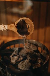 a wooden spoon filled with water in a bowl at Lavender Hill, Eko Resort & Wellness in Polzela