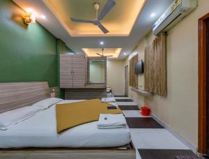 1 Schlafzimmer mit 2 Betten und einem Deckenventilator in der Unterkunft Hotel RadhaKrishna-Couple Friendly in Kolhapur