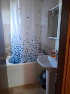 baño con cortina de ducha azul y lavamanos en 2 Bedroom, 1 Bath apartment near the sea en Casal Velino