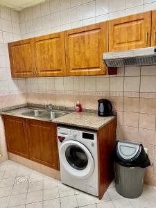 een keuken met een wasmachine en een wastafel bij Robin Hostel Dubai in Dubai