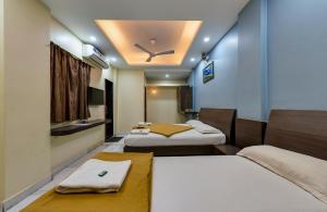 Zimmer mit 2 Betten und einer Decke in der Unterkunft Hotel RadhaKrishna-Couple Friendly in Kolhapur
