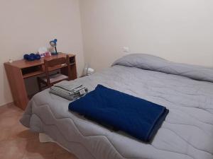 1 cama con manta azul y escritorio en 2 Bedroom, 1 Bath apartment near the sea en Casal Velino