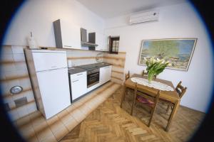 a kitchen with a table and a white refrigerator at Apartment Lavanda in Zadar